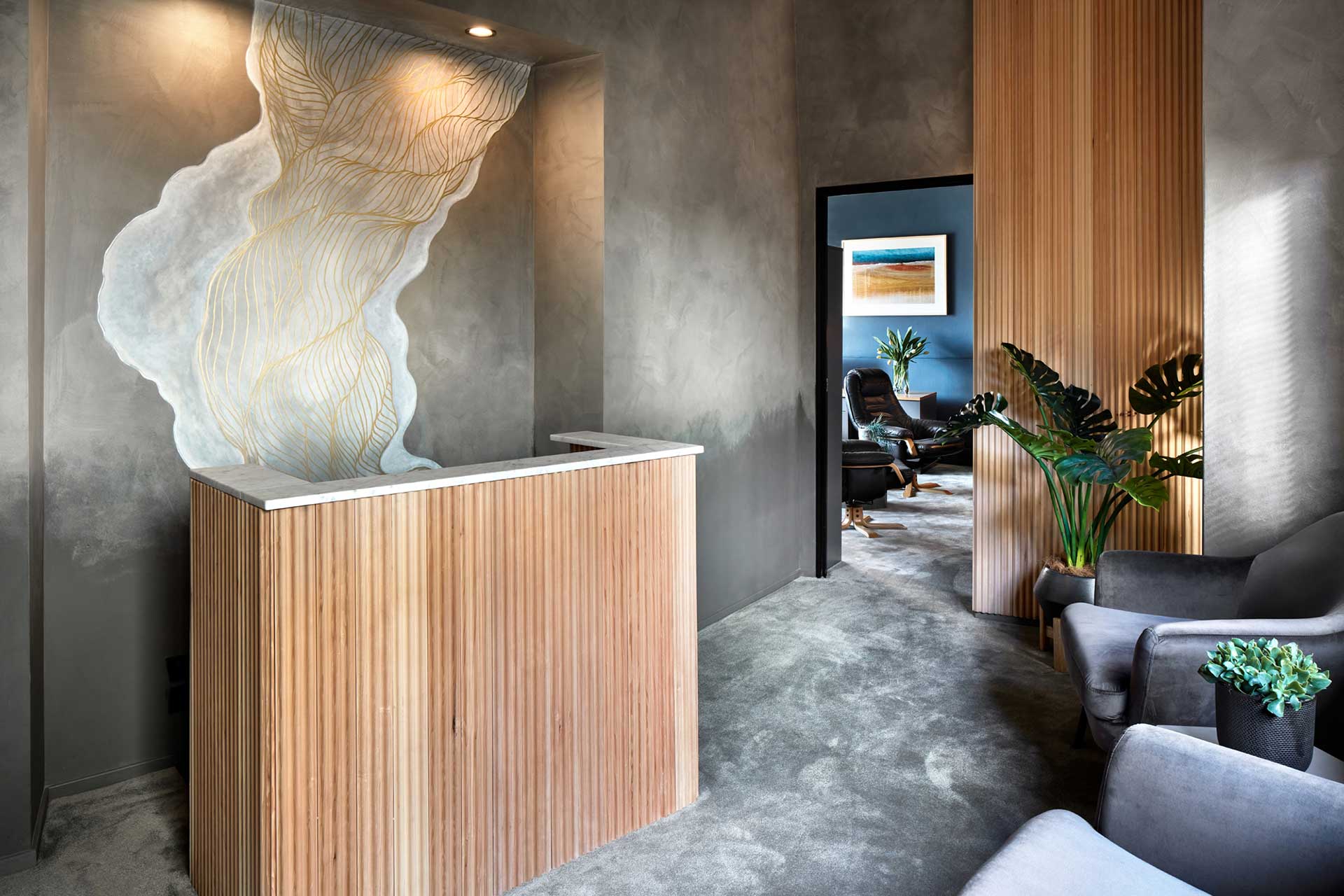 Reception desk with fluted timber and a painted mural in an Edgecliff therapy practice
